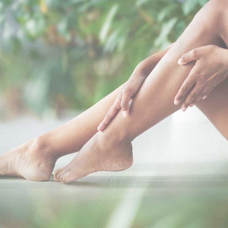 A women's rubbing her smooth lower legs.